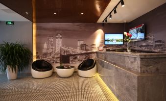 The lobby features two chairs and a white-painted artistic wall in the background at Super 8 Hotel Premier (Beijing Workers' Stadium Sanlitun Chunxiu Road)