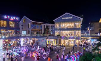 At night, a cityscape with illuminated buildings and a clock tower in the background at Zhenmei Resort Chain Hotel(Yangshuo West Street AiYuan Store)