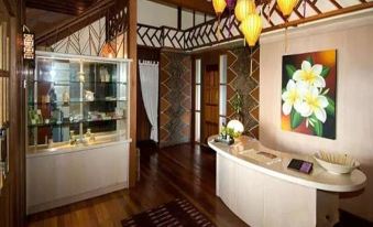 The room features two large wooden doors and an ornate chandelier suspended from the ceiling at Mabul Water Bungalows