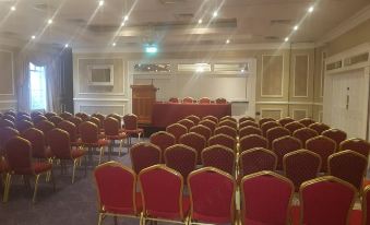 a large conference room with rows of chairs arranged in a semicircle , and a podium at the front of the room at Talbot Hotel Wexford