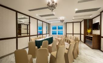 A spacious conference room is arranged with tables and chairs for events or meetings at Ramada Hong Kong Grand View