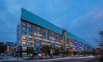 A large building in the middle is illuminated by lights, offering an outside view at night at Kaison Pusham Hotel