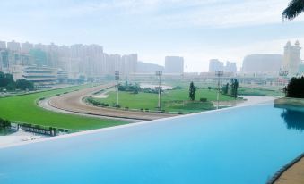 A large pool overlooks an urban setting with buildings in the background at The Macau Roosevelt