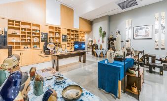 The room in front of the table is an art gallery with various types of artwork on display at Ceramik Hotel (Foshan Lecong Furniture City)