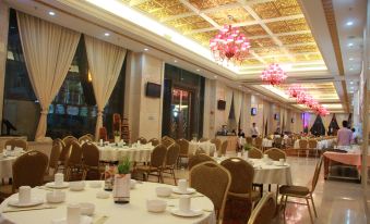 a large banquet hall filled with round tables and chairs , ready for a formal event at Regency Hotel