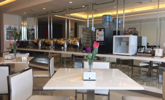 There is a restaurant in the middle of the hotel with tables and chairs, as well as other rooms at Jinjiang Inn Style (Shanghai Pudong Airport Town)