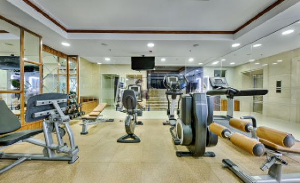 a well - equipped gym with various exercise equipment , including treadmills , weight machines , and a bike rack at Paris Deli Danang Beach Hotel