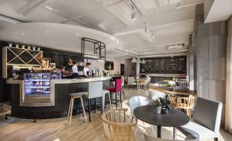 The restaurant features a front area with tables and chairs, as well as a bar on one side at Campanile Hotel (Shanghai The Bund)