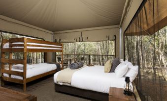 a spacious bedroom with two beds , one of which is a bunk bed , and a wooden deck at Paradise Country Farmstay