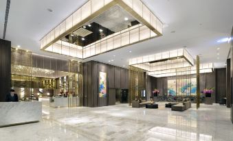 a large , modern hotel lobby with marble floors and high ceilings , featuring a reception desk , chairs , and a painting on the wall at Caesar Park Hotel Banqiao