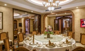 a large dining room with a round table set for a formal dinner , surrounded by chairs at Wellington Hotel