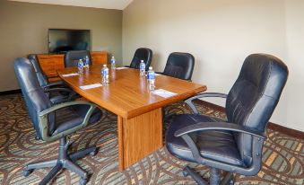 a conference room with a wooden table surrounded by black chairs and water bottles on the table at Best Western Pembroke Inn  Conference Centre