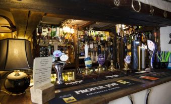 "a well - stocked bar with various beer taps and a sign reading "" porter job "" on the wall" at The Hatchet Inn