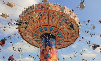 a colorful carousel with a vibrant design is suspended from the ceiling , surrounded by blue skies at The Black Swan