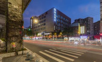 At night, there is a city street with a building in front and an office block across from it at Discovery Hotel (Guangzhou Railway Station Sanyuanli Subway Station)