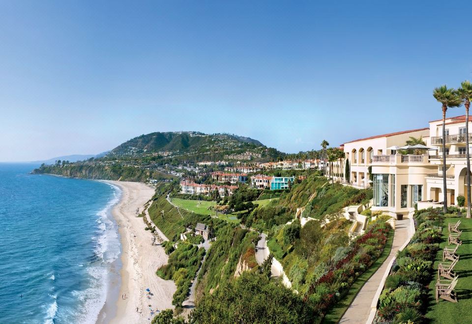 a panoramic view of a beachfront property with a house on the cliff , overlooking the ocean at The Ritz-Carlton, Laguna Niguel