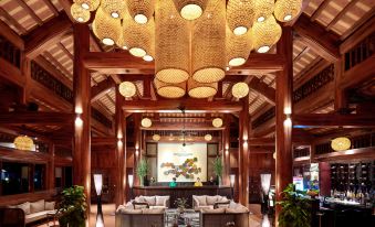 a large room with wooden walls and a wooden ceiling has chandeliers hanging from the ceiling at Tam Coc La Montagne Resort & Spa