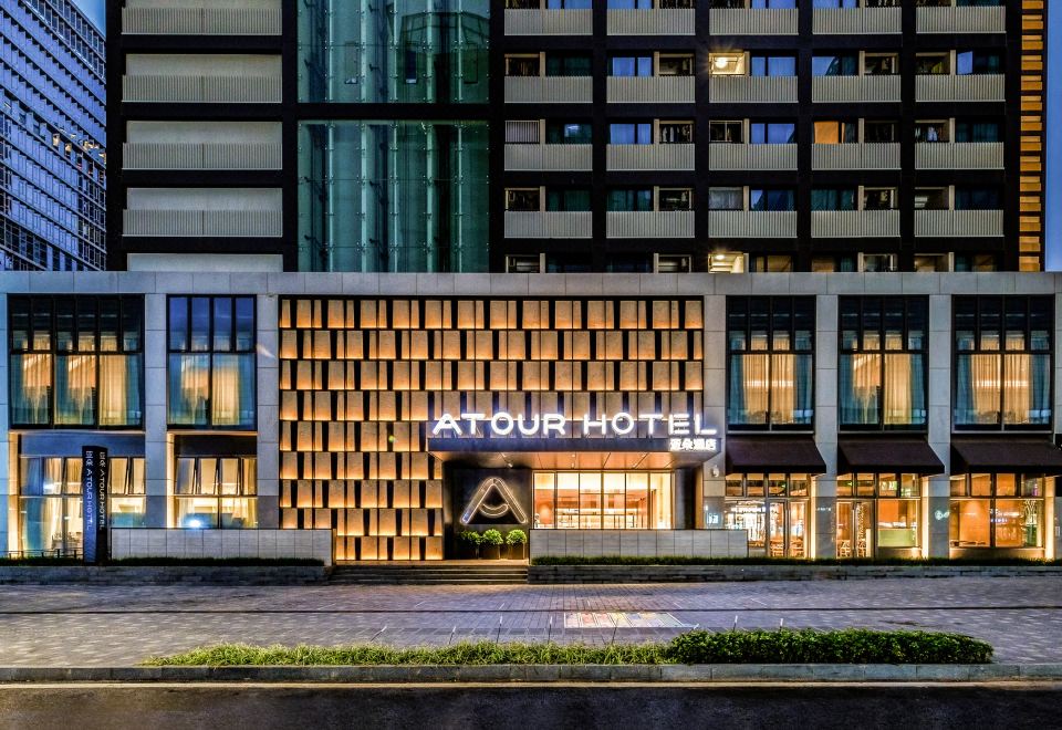 A hotel with an art deco style entrance is illuminated at night at Atour Hotel (Shenzhen Nanshan Vanke Yuncheng)