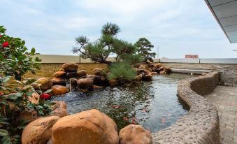 In the middle of the pond, there are rocks and trees, and next to it is an artificial water feature at Lavande Hotel