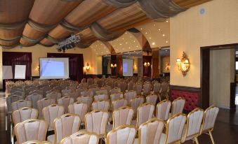 a large conference room with rows of chairs arranged in a semicircle , ready for an event at Platinum Hotel