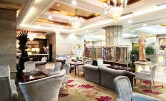 a luxurious hotel lobby with various seating options , including couches , chairs , and a dining table at Relax Hotel