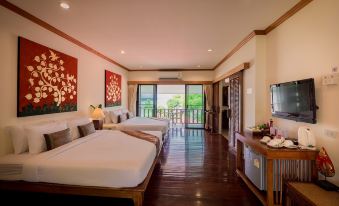 a hotel room with two beds , a television , and a balcony overlooking a beautiful view at Chiangkhan River Mountain Resort