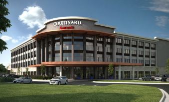 "a modern hotel with the sign "" courtyard by marriott "" on top of a building , surrounded by green grass and trees" at Courtyard Austin Pflugerville and Pflugerville Conference Center