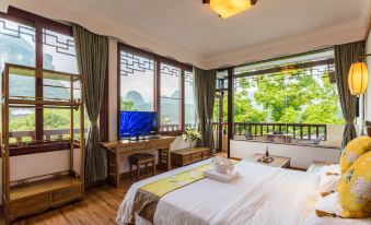 a bedroom with a large bed , wooden furniture , and a view of the mountains outside the window at Riverview Hotel