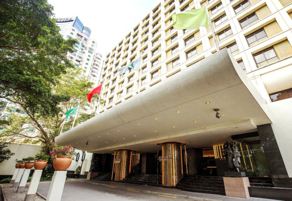 The hotel entrance features large windows that provide a view of another building in front at Regency Art Hotel