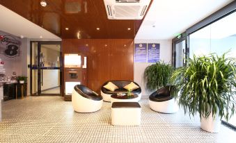 In the lobby, there are chairs and tables arranged in the middle, as well as an adjacent office space at Super 8 Hotel Premier (Beijing Workers' Stadium Sanlitun Chunxiu Road)