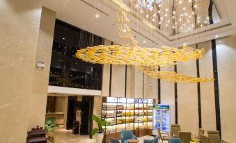 a well - lit room with a chandelier and a chandelier hanging from the ceiling , surrounded by chairs and tables at DTX Hotel Nha Trang