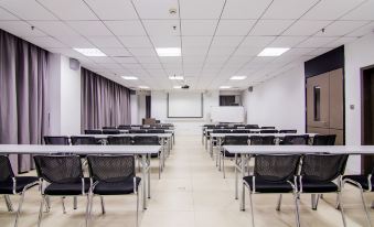 There is an empty classroom with rows of desks and a whiteboard on the wall behind them at Home Inn Selected (Shanghai Wuning Road Metro Station Anyuan Road)