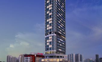 a tall building with a blue sky in the background , and other buildings in the foreground at Hompton Hotel by The Beach