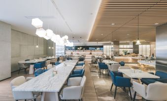 In the center of the restaurant, there are tables and chairs arranged in a way that they all face each other at Atour Hotel (Yiwu International Trade City)