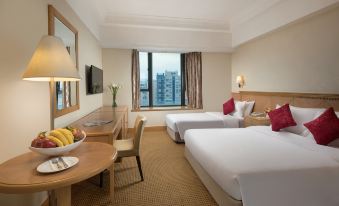 The bedroom features double beds, a desk, and a chair positioned in front of a large window with a view of another area at Ramada Hong Kong Grand View