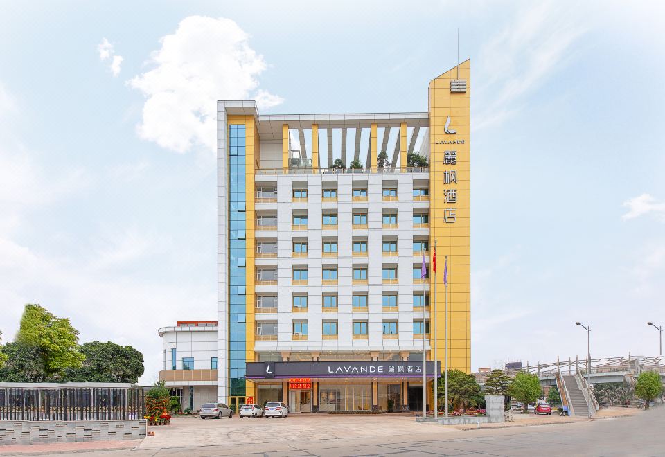 From across a parking area, there is a view of the exterior of an apartment complex at Lavande Hotel