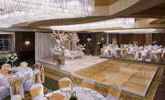 a large banquet hall filled with tables and chairs , where a wedding reception is taking place at Hilton Cairo Grand Nile