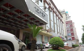 In an urban setting, there is a hotel and restaurant entrance surrounded by parked cars at Byfond Hotel