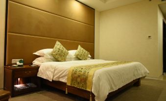 a large bed with white sheets and a gold headboard is in a hotel room at Spring Hotel