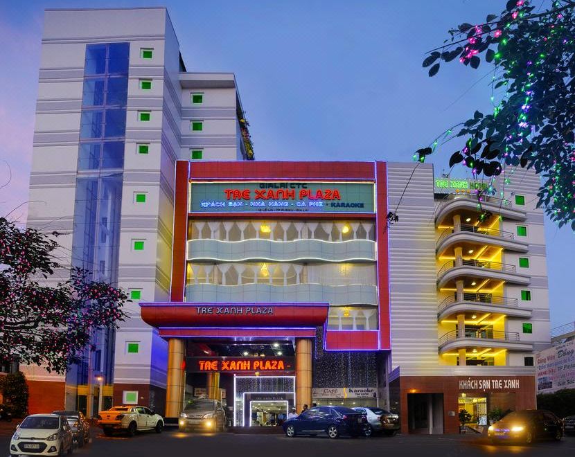 "a large building with a red sign that says "" the farmers "" and another sign that says "" the management building ""." at Tre Xanh Hotel