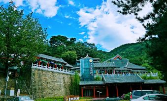 In the background of the city, there are buildings and mountains, with one of the buildings having an oriental style at Mutianyu Great Wall Hotel