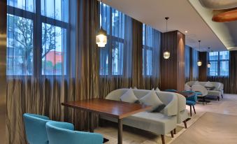 elegant and spacious suite, featuring ample natural light, comfortable seating, and a well-appointed dining space at Orange Hotel (Shanghai Pudong Airport)