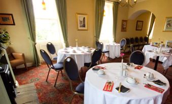 a dining room with tables and chairs set up for a formal event , possibly a wedding reception at Anchor Hotel