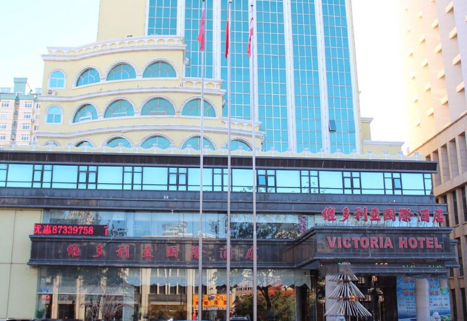 a large building with a blue and white color scheme , located in a city setting at Victoria International Hotel