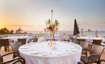 a large dining table set for a formal event , with multiple chairs arranged around it at Manolya Hotel