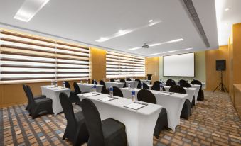 a conference room with white tables and black chairs , a projector screen , and a podium at Holiday Inn Express Nantong Downtown