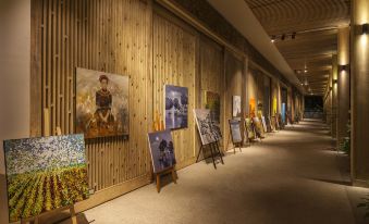 a long hallway with paintings on display , creating an art gallery - like atmosphere that suits both traditional and contemporary styles at Salinda Resort Phu Quoc - Sparkling Wine Breakfast