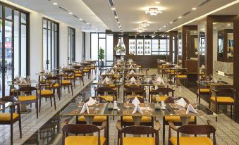 a large dining room filled with tables and chairs , all set for a formal dinner at Senna Hue Hotel