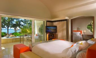 a hotel room with a king - sized bed and a large window overlooking the ocean , providing a scenic view at SO Sofitel Mauritius