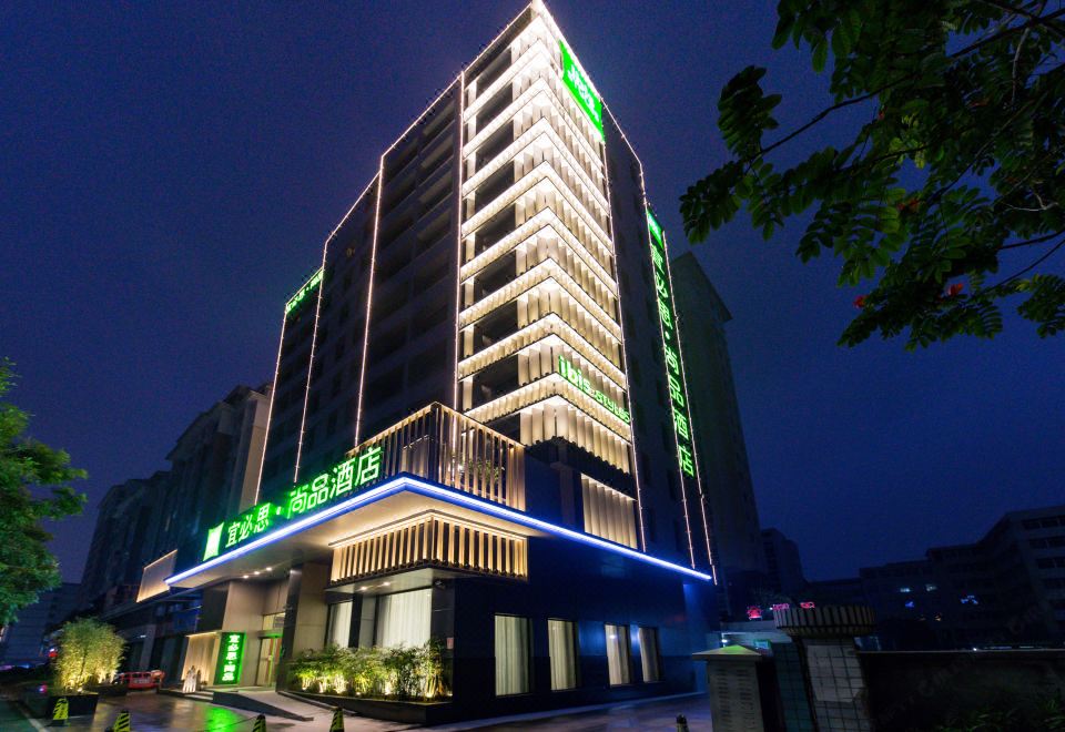 "a tall building with multiple floors , lit up at night , and a sign that reads "" hotel ""." at Ibis Styles Hotel